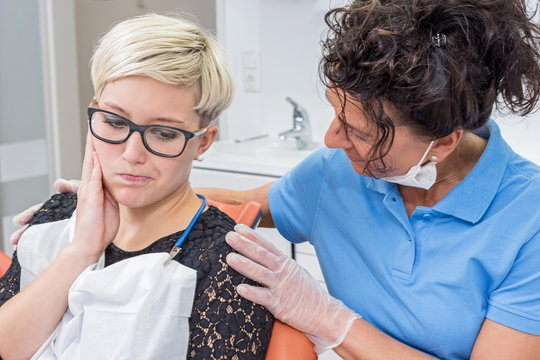 Zahn&auml;rztin beruhigt eine Patientin mit Zahnschmerzen