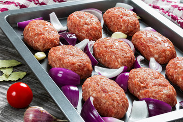 fresh ground raw meat cutlets in baking dish