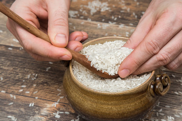 Rice in the bowl on the wooden table in the kitchen. Healthy eating and lifestyle.