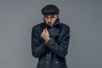 A man in a jacket on grey background.