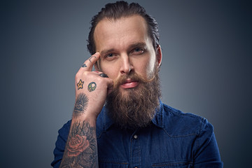 Bearded male with tattoos on arms.