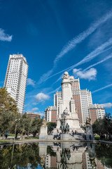 Square of Spain in Madrid with Cervantes monument and skyscraper on background. Blue sky day
