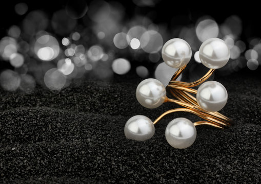 Jewelry ring with pearls on black background with bokeh
