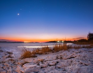 sunset on the river in the winter stars and moon