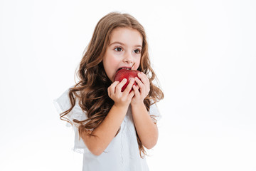 Pretty cutly little girl biting and eating red apple