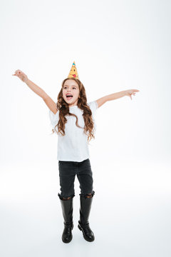 Smiling little girl in birthday hat celebrating and shouting