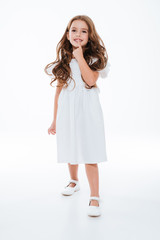 Fototapeta premium Happy cute little girl in dress smiling and walking