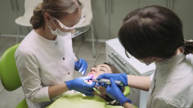 Dentists treat tooth girl.  4k footage. Dental Curing Light. Close-up.
