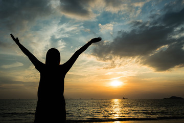 Fototapeta premium silhouette of woman pointing with finger in sky on the beach