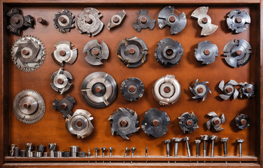 Composition of circular saws and milling cutters. Carpenter tools on a workplace.