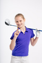 Pretty girl golfer posing with golf club and ball on white backgroud in studio