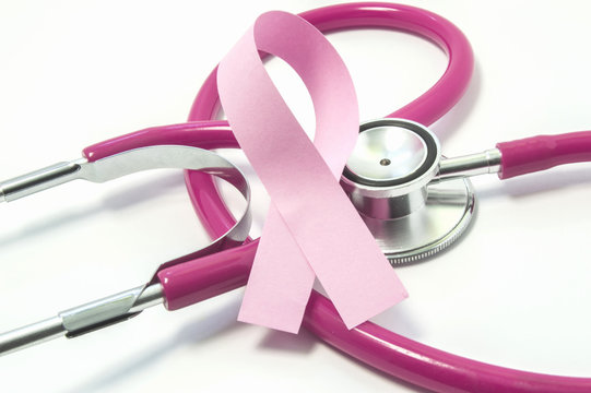 Concept of Breast Cancer. Pink ribbon near the pink-purple stethoscope doctor of breast screening, symbolizing the diagnosis, treatment, fight, awareness and support  of women's breast cancer close up