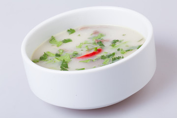 A plate with cream soup on gray background.