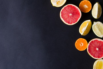 various types of citrus fruit on a dark background