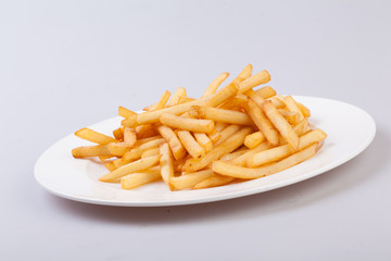 White plate with french fries on gray background.