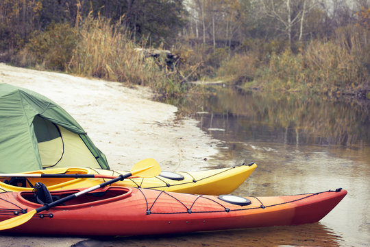 Camping with kayaks on the river bank.