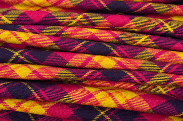 Scottish tartan pattern on folded fabric. Red plaid print as background