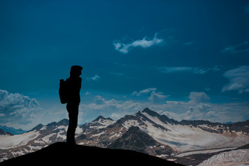 Fototapeta premium man against the sea standing on a mountain top looking into the distance