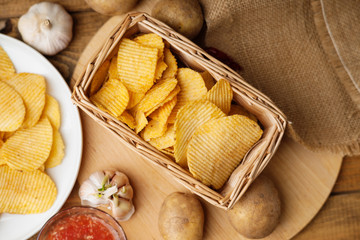 Crispy potato chips in a wicker basket 
