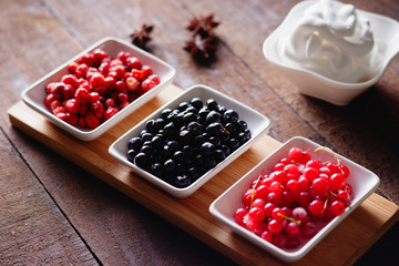 Berry fruits in a dishes and whipped cream
