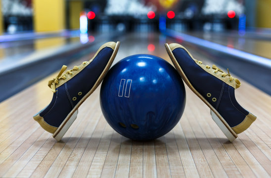 Bowling ball and shoes on lane background