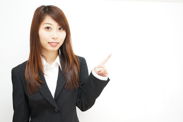 Young woman pointing something with white  background