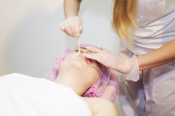 Depilation with hot wax mustache in the beauty salon. 