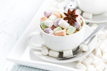 cocoa with colorful marshmallows and spices in white cups