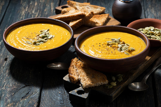 Delicious pumpkin soup on wooden table