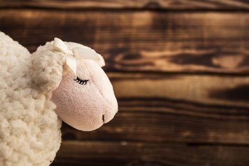 toy white lamb face on wood
