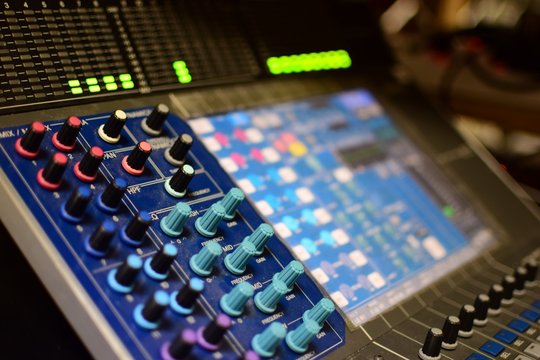 Shallow Depth-of-field Generic Photo of Concert Music Broadcast Soundboard Mixer and Equalizer with Knobs and Audio Volume Indicator Lights Shallow Depth-of-field