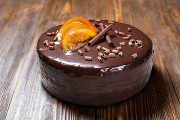 chocolate cake with Candied Oranges,Chocolate cake with a cut piece and blade on dark background, closeup,Dark chocolate cake,Delicious vegan chocolate cake,Tasty chocolate cake on wooden background