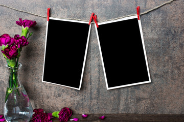 blank photo frames hanging on rope with purple carnation flowers