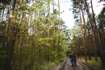 Happy young couple walking through the  forest