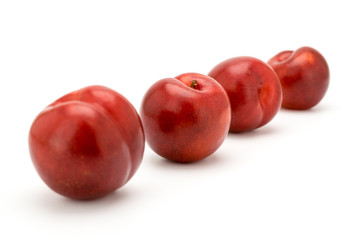 Four ripe cherries on a white