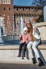 Obraz na płótnie Canvas mother and daughter near Sforza Castle in Milan handwaving