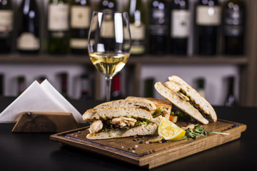 Close up of delicious sandwiches.  Beautifully served meal at the restaurant. Wine glass in the background.