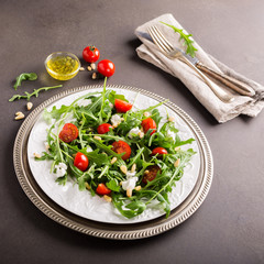 fresh vegetable salad with rucola, tomatos and goat cheese. Healthy food concept.