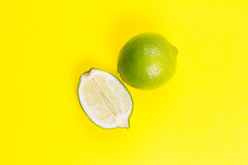Whole and sliced llime on yellow background