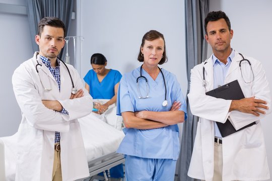 Portrait of doctors and nurse standing with arms crossed