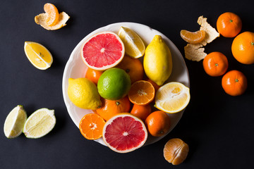 various types of citrus fruit on a dark background