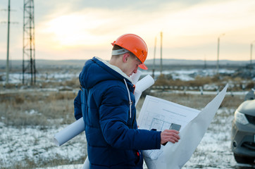 The man worker wear a orange helmet with construction site
