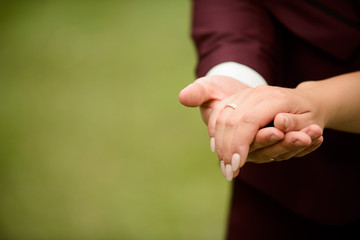 Closeup of groom placing ring on brides finger on their