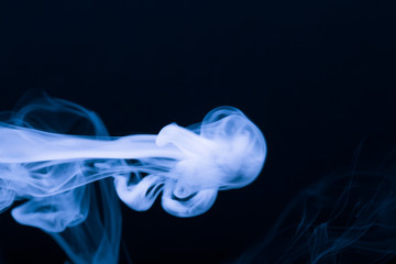 Cloud of smoke on black background. Selective focus. Toned