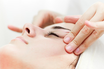 Obraz na płótnie Canvas Facial massage.Beautiful young woman getting facial massage in beauty salon