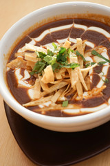 Tomato soup and red beans with cream and spices, Mexican food on a white table background.