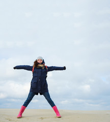 energetic funny young woman enjoying life and posing on on winter beach. energy, freedom, success concept