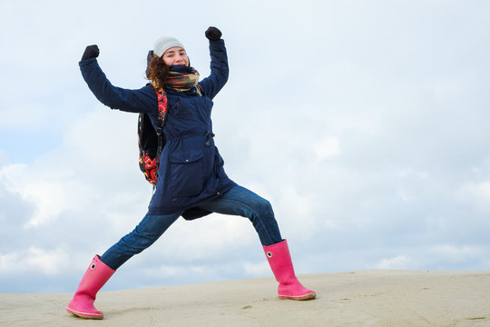 energetic funny young woman enjoying life and posing on on winter beach. energy, strength, power, success concept