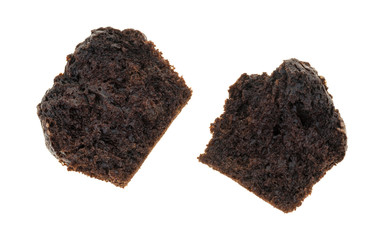 Broken double chocolate muffin on a white background top view.