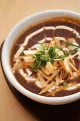 Tomato soup and red beans with cream and spices, Mexican food on a white table background.